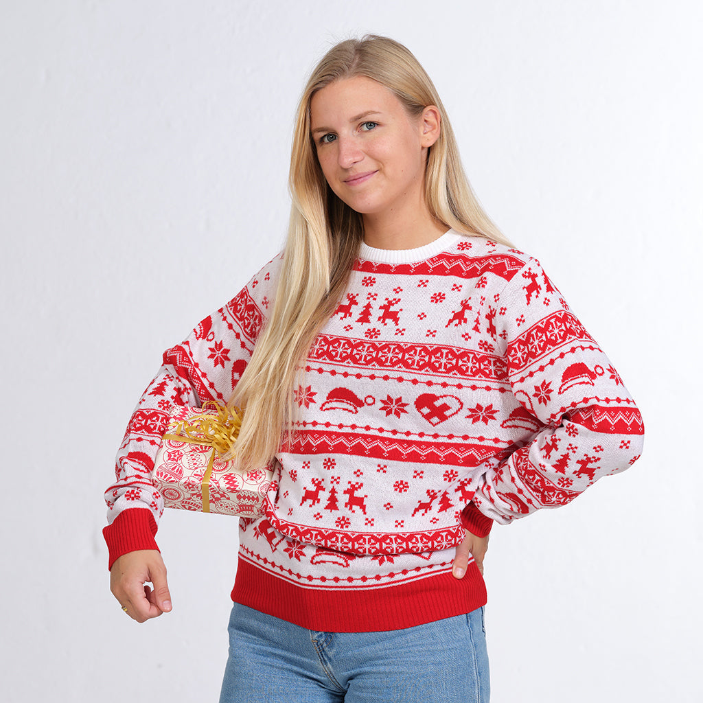Kvinna i rödvit jultröja med julhjärtan, tomteluvor och renar.